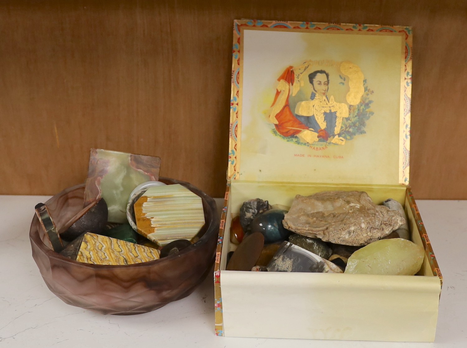 A collection of mineral and hardstone specimens and gem stones contained in a cigar box and a Davidson‘s cloud glass bowl